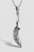 Silver pendant on a chain against a light gray background